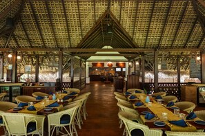 An indoor restaurant with wicker furniture, a wooden ceiling, and a central walkway. - Marari Beach Resort - A CGH Earth Experience (Cherthala)