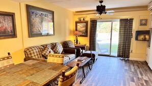 A living room with a sofa, a dining table, and a television.