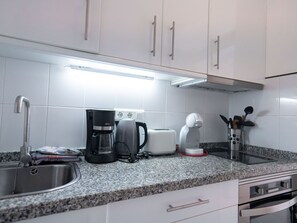 A kitchen with a stainless steel sink, a coffee maker, a toaster, and a kettle. - Apartment  by Interhome (Nerja)