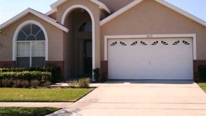A single-story house with a garage, a front entrance, and a small front yard. - Disney Area Budget Homes (Davenport)