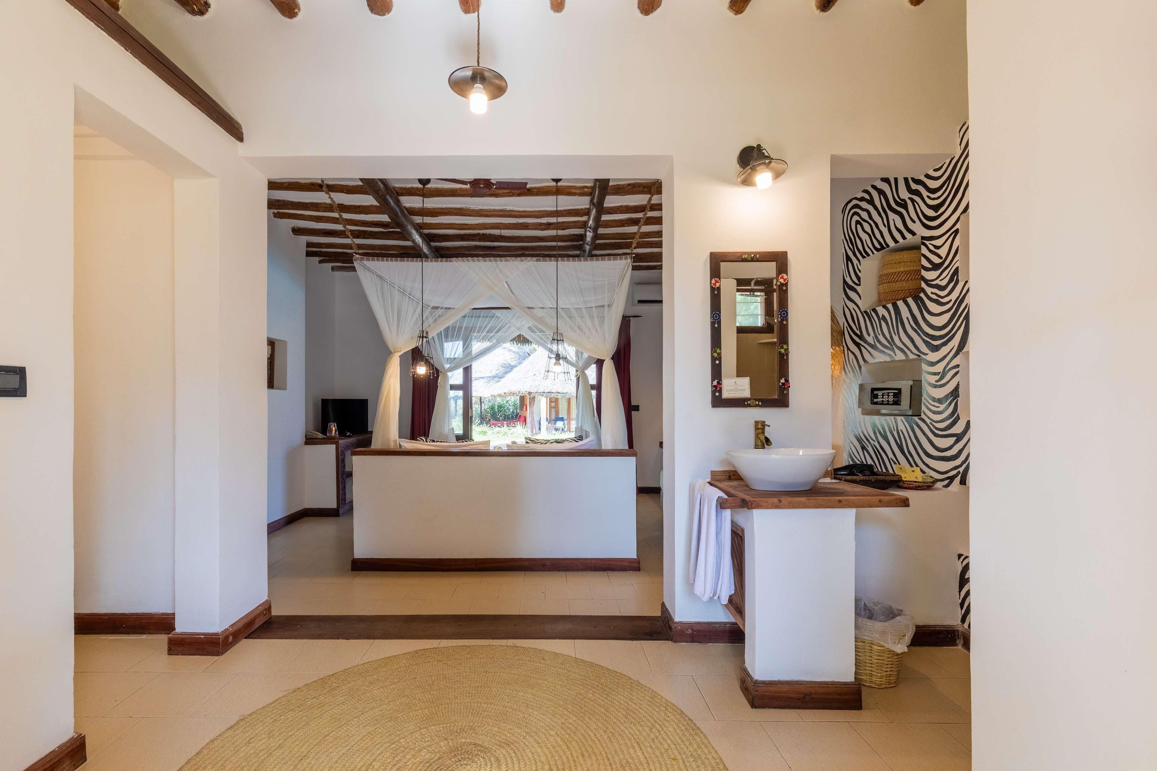 Um hall de hotel com uma ilha central, parede com padrão de zebra e um espelho grande.
