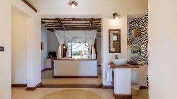 Um hall de hotel com uma ilha central, parede com padrão de zebra e um espelho grande.