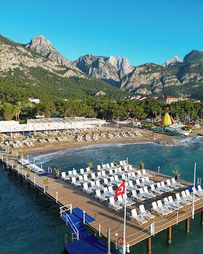 A coastal resort with a pier, sun loungers, and a flag. - Catamaran Resort Hotel (Kemer)