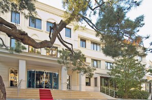 A multi-story building with a grand entrance, a staircase, and a large tree in front. - Anemon Gonlu Ferah Bursa (Bursa)