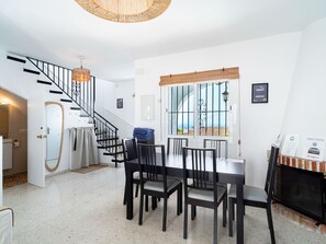 Ein modernes Interieur mit Treppe, Essbereich und Blick durch ein Fenster.