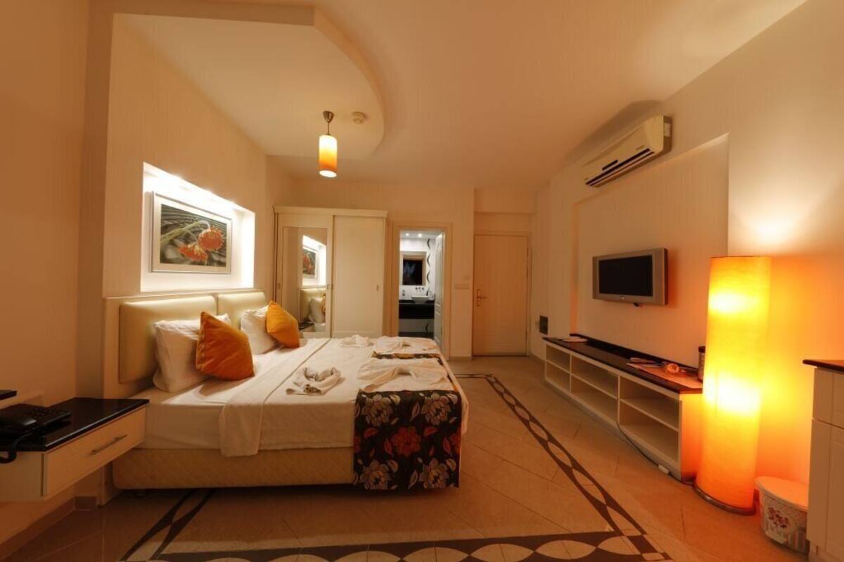 Ein Hotelzimmer mit Bett, Schreibtisch, Fernseher und Bad.