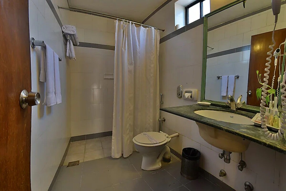 A bathroom with a toilet, sink, and shower curtain.