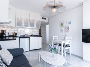 A modern kitchen with white cabinets, a black countertop, and a coffee maker. - Apartment  by Interhome (Nerja)