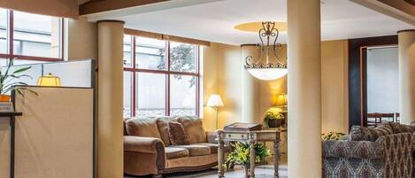 A spacious lobby with high ceilings, large windows, and a central column.