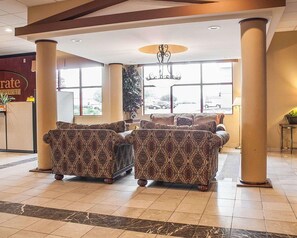 A lobby with patterned sofas, large windows, and a chandelier. - Quality Inn Airport Buffalo (Buffalo)