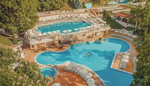 An aerial view of a resort with multiple swimming pools, sun loungers, and a large building with a pool deck. - Grifid Hotel Bolero (Varna)