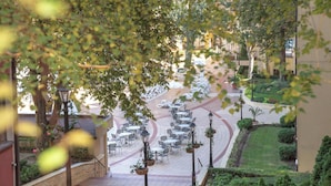 A courtyard with outdoor seating, a central pathway, and surrounding greenery. - Grifid Hotel Bolero (Varna)