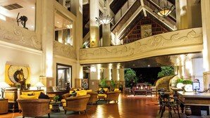 A spacious lobby with high ceilings, ornate wall decorations, and multiple seating areas.