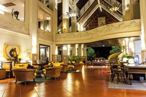 A spacious lobby with high ceilings, ornate wall decorations, and multiple seating areas. - Mission Hills Phuket Golf Resort & Spa (Wichit)