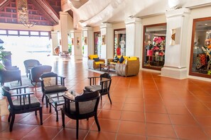 A spacious lobby with a high ceiling, tiled floor, and a seating area with chairs and sofas. - Mission Hills Phuket Golf Resort & Spa (Wichit)