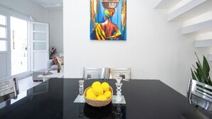 Et moderne spiseområde med et sort bord, klare glas og en kurv med citroner.