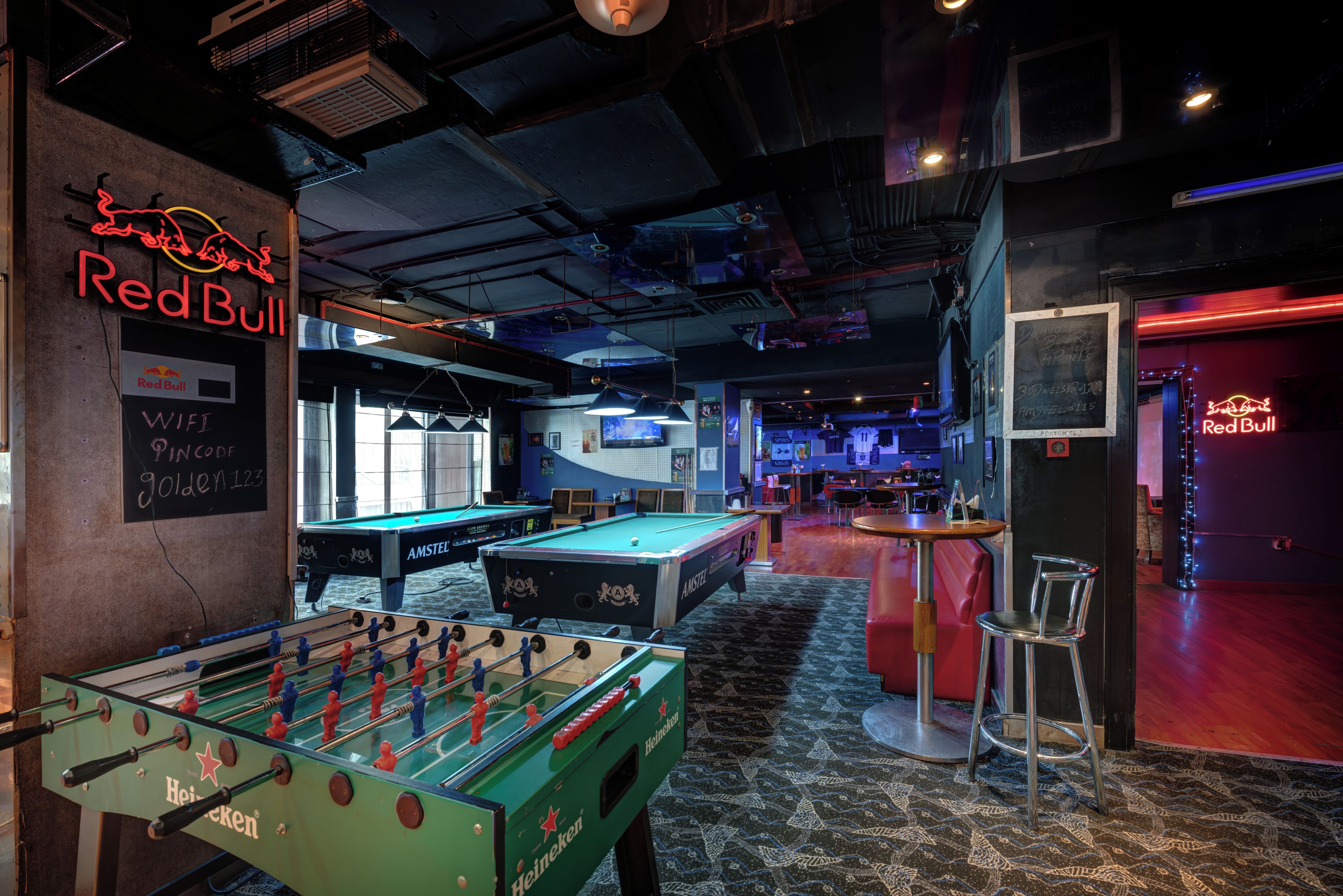 A Red Bull bar with foosball tables and a pool table, indicating a gaming area.
