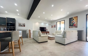 A modern living room with a sofa, a TV, and artwork on the walls.