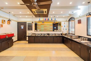 Una cocina moderna con una isla central, armarios oscuros y un ventilador de techo.