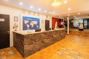 Una recepción con un mapa mundial, relojes y un cartel que indica 'Solo personal'.