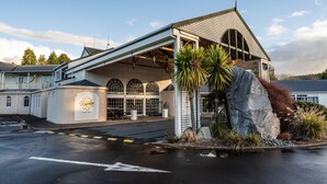 A building with a large rock feature, a covered entrance, and a sign indicating it is a resort.