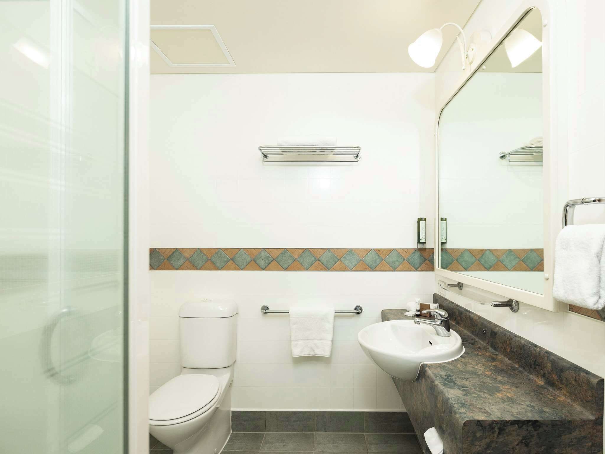 Ein Badezimmer mit Toilette, Waschbecken und Dusche.