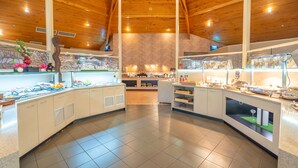 A modern kitchen with wooden ceilings and a central island.