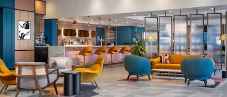 A modern bar area with seating, a counter, and a decorative plant.