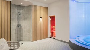 Un baño moderno con ducha, bañera y zona de estar.