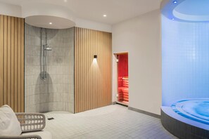 A modern bathroom with a shower, a bathtub, and a seating area. - Voco Fareham-solent (Fareham)