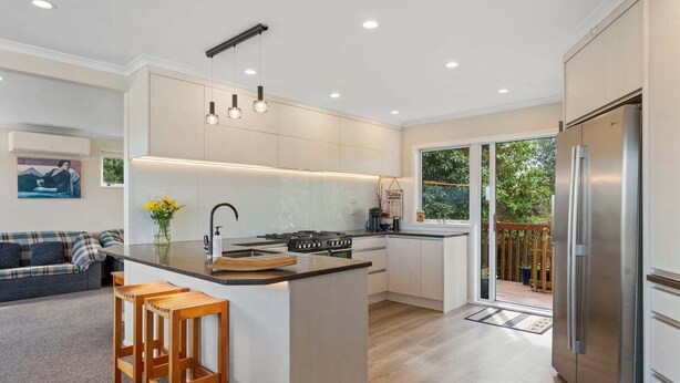 Una cucina moderna con isola centrale, piano cottura integrato e frigorifero in acciaio inossidabile.