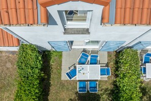 An aerial view of a building with a rooftop terrace, a table with chairs, and a small garden area. - Le Domaine de L'océan (Saint-Brevin-les-Pins)