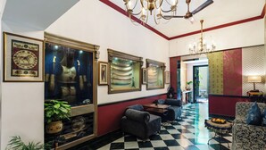 A hotel lobby with a checkered floor, framed artwork on the walls, and a chandelier. - Panna Villas Udaipur (Udaipur)