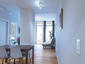 A modern living room with a dining area, a large window, and a view of the outdoors. - BS Miró II - Marktplatz HITrental Apartment by Interhome (Basel)