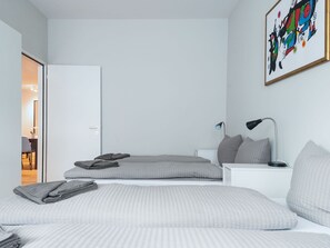 Une chambre à coucher moderne avec un lit, des tables de chevet, une lampe et un tableau au mur.