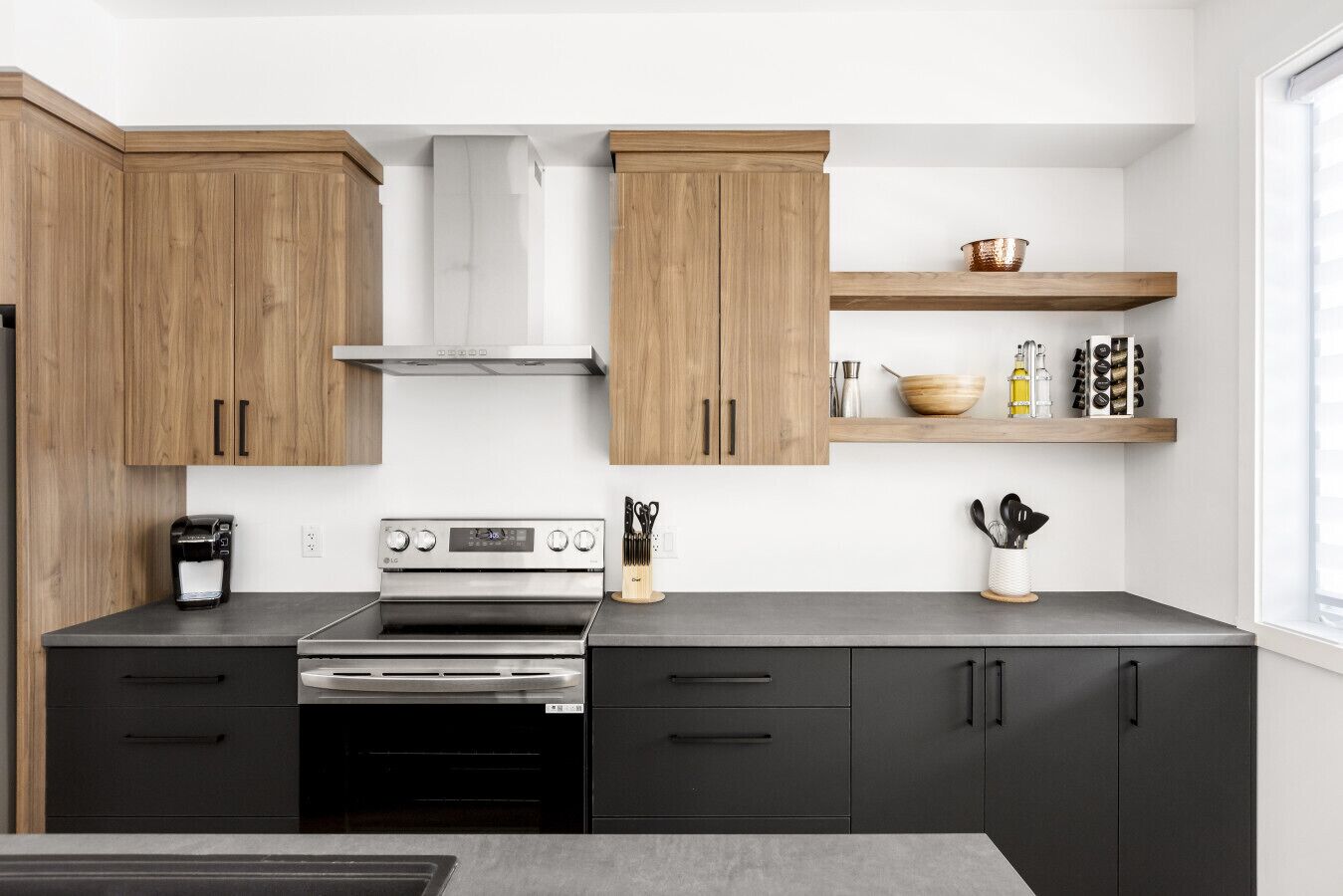 Een moderne keuken met houten kastjes, een roestvrijstalen fornuis en een koffiezetapparaat.