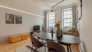 A modern living room with a dining table, sofa, and artwork on the wall. - Apartment  by Interhome (Porto)
