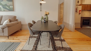 A modern living room with a dining table, sofa, and kitchen in the background. - Apartment  by Interhome (Porto)