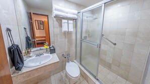 A bathroom with a glass shower enclosure, a sink, and a toilet.