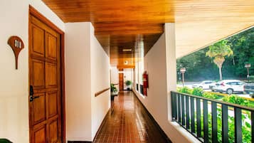 A corridor with a wooden ceiling, a door marked '318', and a balcony with a railing.