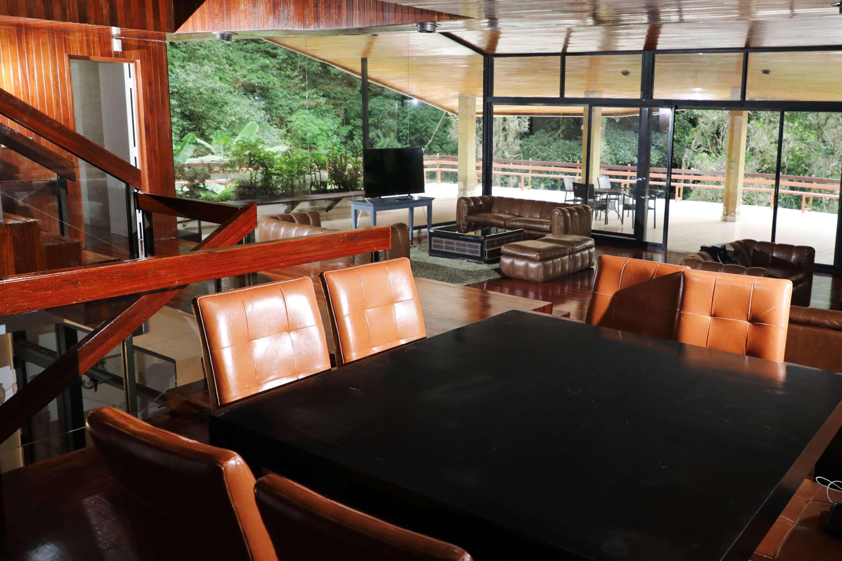 A modern interior with a dining area, leather seating, and a view of the outdoors.