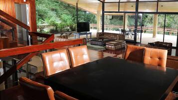 A modern interior with a dining area, leather seating, and a view of the outdoors.