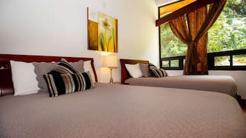 Two beds with headboards, a bedside lamp, a painting, and a window with curtains.
