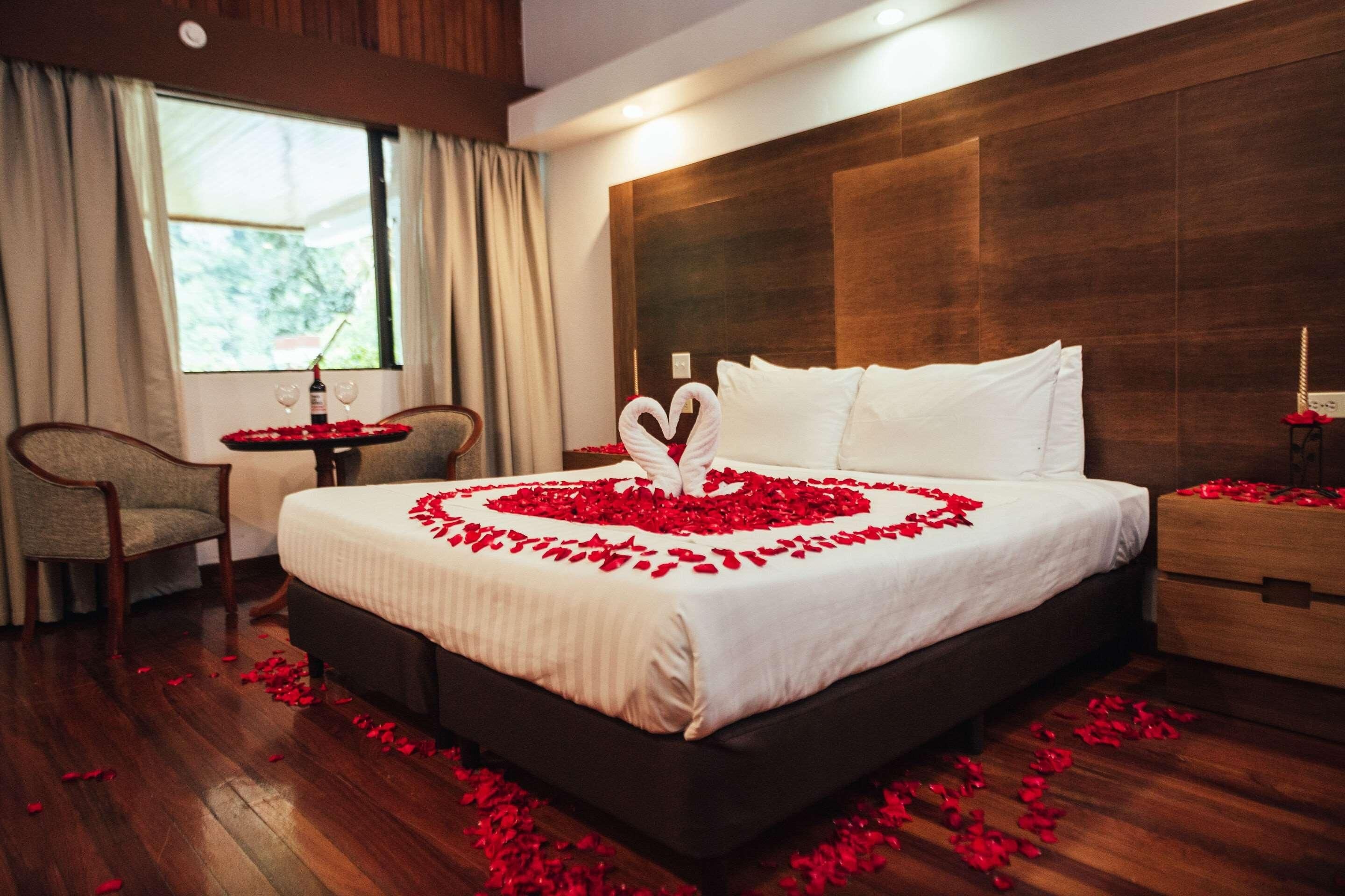 A hotel room with a bed, a nightstand, a chair, and a window.