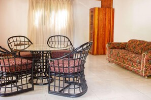 A dining area with a table and chairs, a sofa, and a wooden cabinet. - Hotel Bambito By Faranda Boutique, A Member Of Rad (Cerro Punta)