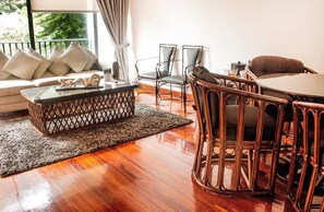 A cozy living area with a sofa, a coffee table, and a dining table with chairs. - Hotel Bambito By Faranda Boutique, A Member Of Rad (Cerro Punta)