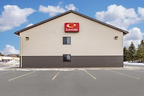 A building with a sign for EconoLodge, a parking lot, and a clear sky. - Econo Lodge Ithaca Area (Ithaca)
