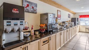 Une cuisine professionnelle équipée d’une machine à café Folgers, d’un espace dédié à la préparation du café et d’un réfrigérateur.
