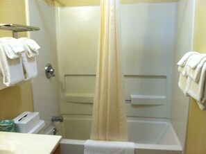A bathroom with a shower, a towel rack, and a toilet.