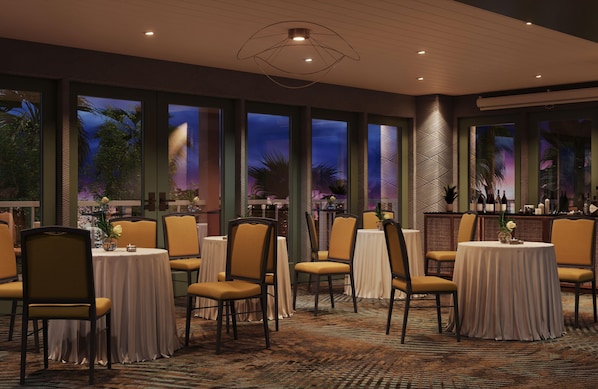 A restaurant with multiple tables and chairs, large windows with a view, and a patterned carpet. - Ocean Key Resort & Spa (Key West)
